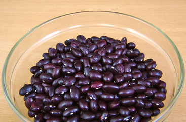 Uncoocked red beans in a cristal bowl on wooden background