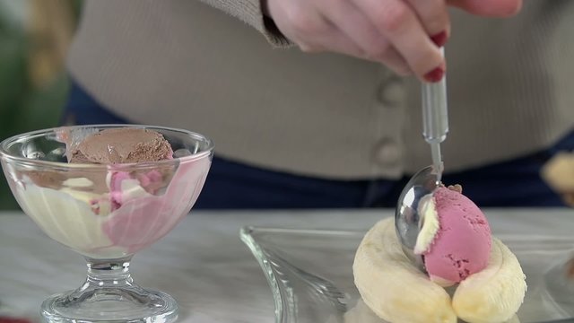 Placing a scoop of ice cream between peeled banana
