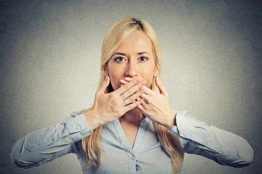 woman covering closed mouth hands grey background 