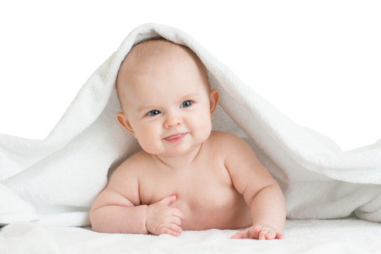 Cute smiling baby kid lying covered by bath towel