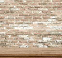 Empty wooden table over brick wall.