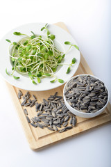 green young sunflower sprouts on salad plate and sunflower seeds