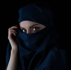 Naklejka premium Young woman wearing hijab on black.