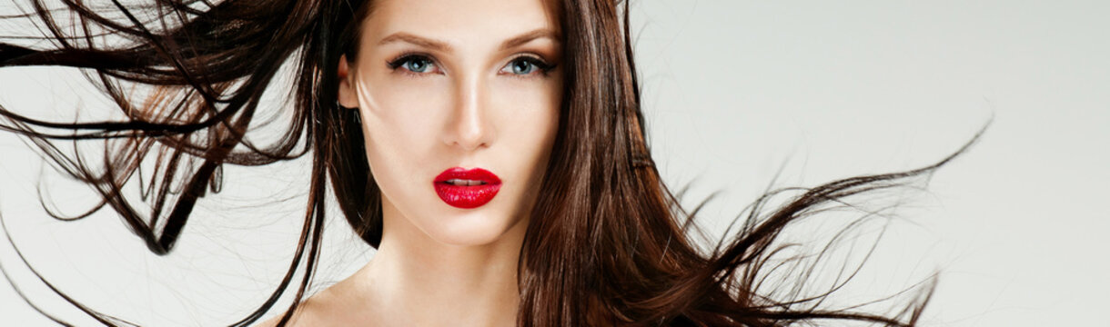 Beautiful woman with magnificent hair. Flying hair. Red lipstick