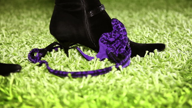 Close up of womans legs in boots taking off her panties