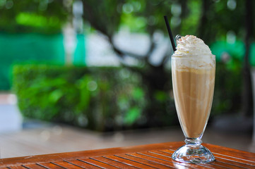 A glass of ice coffee in garden background - 77516340