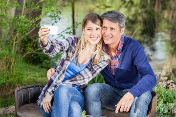 Naklejka premium Happy Couple Taking Selfportrait At Campsite