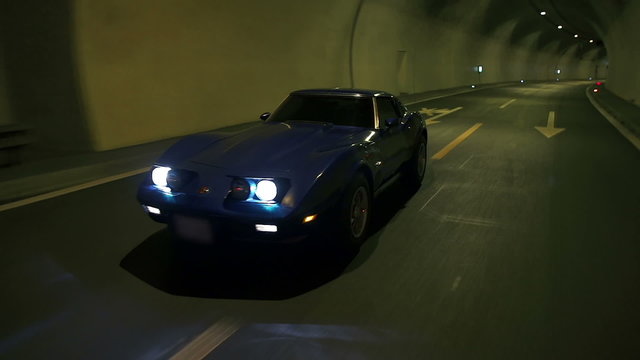 Side shot of blue car night drive through the tunnel