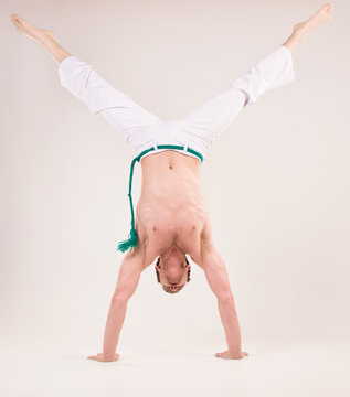 Capoeira dancer on white background