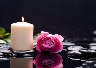 Beautiful rose with candle and therapy stones