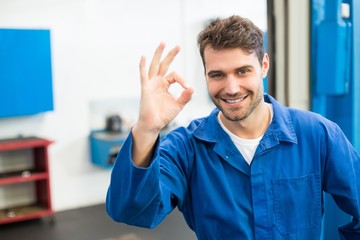 Smiling mechanic showing ok sign