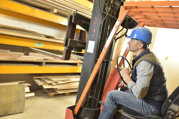 Operator in warehouse driving trolley