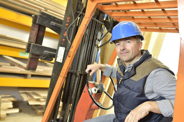 Operator in warehouse driving trolley