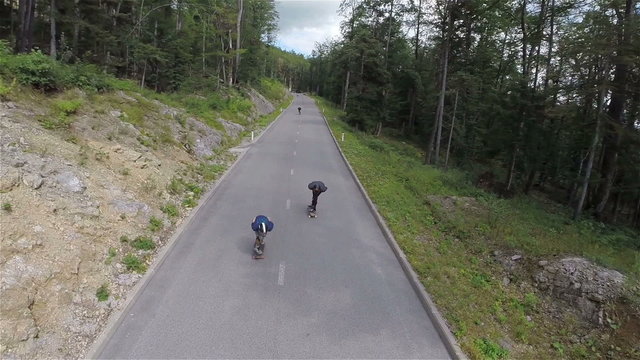 Skate riders speeding down the straight road in slow motion