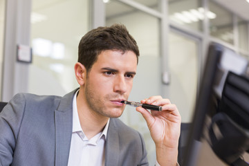 A man in office smoking with electronic cigarette