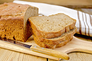 Rye homemade bread stacked on board with napkin