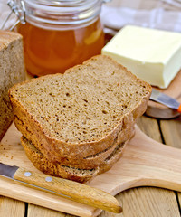 Rye homemade bread with honey and butter on board