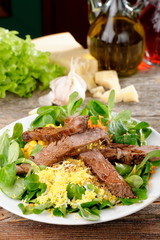 Roast beef with salad of arugula and lettuce with egg