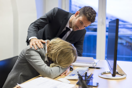 Depressive businesswoman in office with his colleague