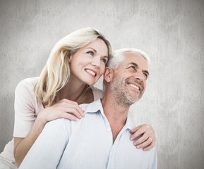 Composite image of smiling couple embracing and looking