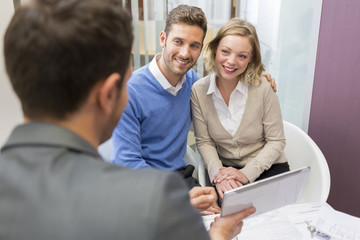 Couple meeting real-estate showing a investment project on pc
