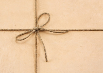 String tied in a bow on a brown recycled paper