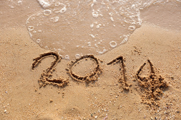 Beaches waves and text 2014 drawn in the sand.