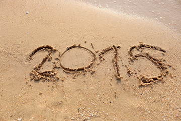 Beaches waves and text 2015 drawn in the sand.
