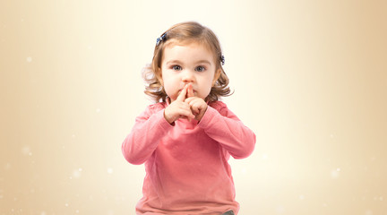 Cute girl doing silence gesture over white background
