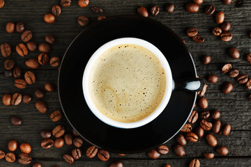 Coffee cup and coffee beans on wood