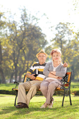 Mature couple relaxing seated on a bench in park