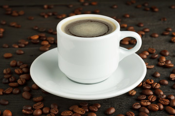 Coffee cup and coffee beans on wood