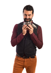 Man wearing waistcoat holding a jar glass with coffee inside