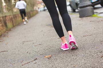 Female Runner Shoes closeup on the road, town setting.