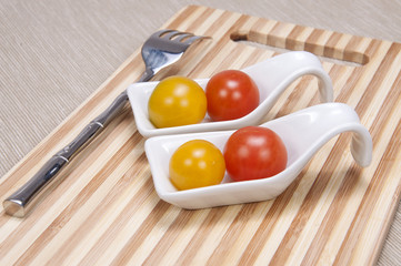 Tomate cherry con cubiertos.