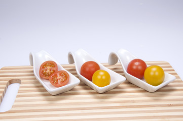 Tomate cherry sobre tabla de madera.