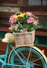 Fototapeta na wymiar Vintage bicycle has beautiful colorful flowers in a basket