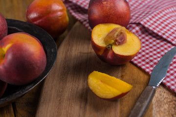 Organic fresh nectarine peach cut on rustic board