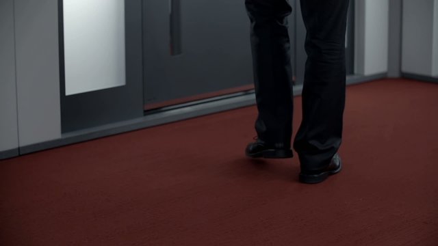 Man in clothes waits in the hallway on the red carpet

