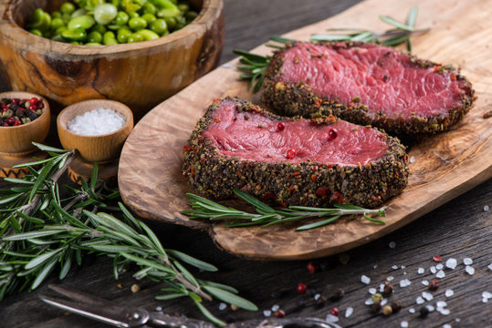 Top view on raw steak with herbs and pepper
