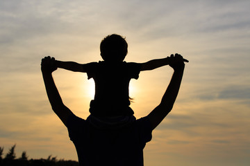 father and son playing at sunset