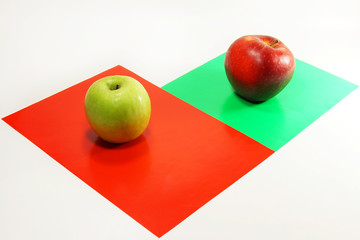 Green and red apples on colored paper