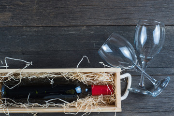 Wine in wooden case with straw and glass from above