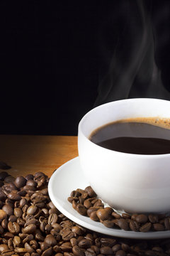 Cup Of Steaming Coffee With Beans