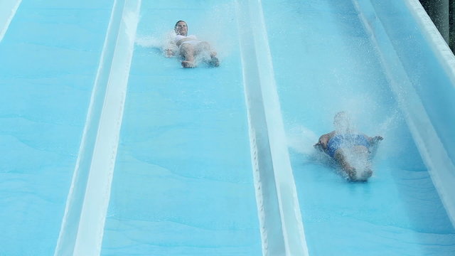 Young couple sliding down the waterslide