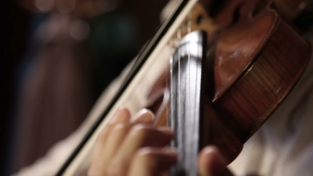 Close up pan shot of a violin player