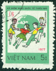 stamp printed in Vietnam shows Children dance around Globe