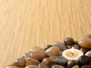 Obraz na płótnie Canvas Zen candle in pebbles on bamboo background