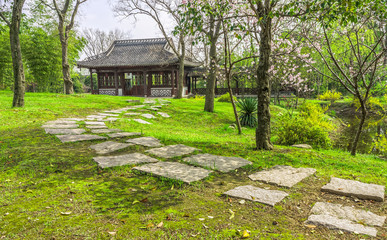 The walkway to a vintage Chinese pavilion in a garden