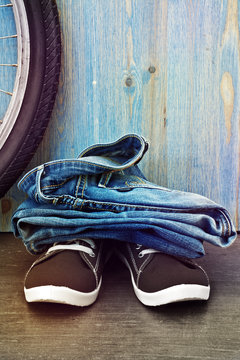 Jeans and sneakers on a background of blue wooden fence